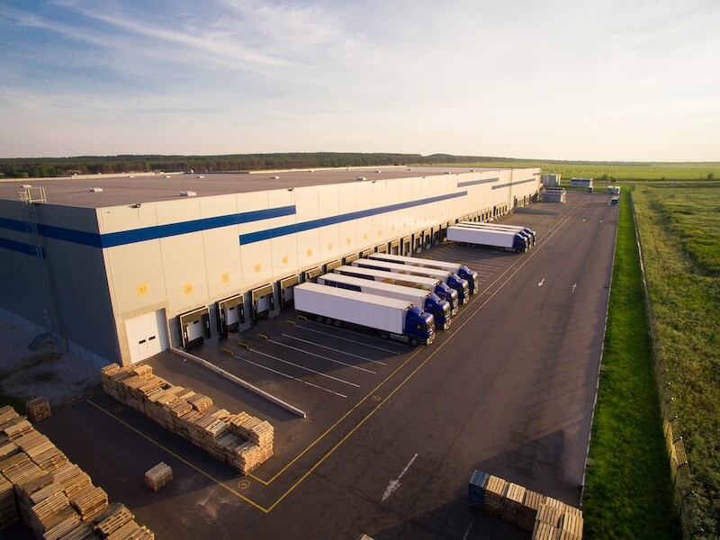 External image of surplus equipment distribution warehouse with trucks of different capacity.